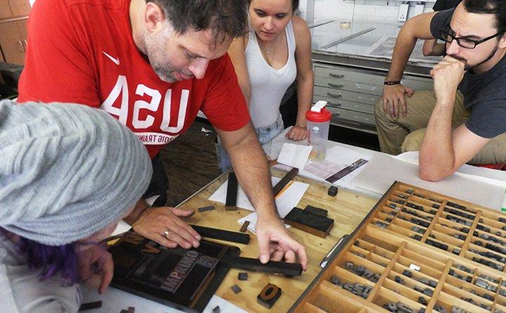 艺术专业的学生参观克利夫兰的合格特出版社，学习字母印刷机的版画制作.